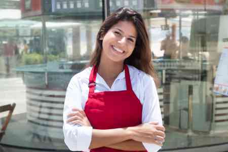 Foto: Junge Kellnerin vor dem Restaurant